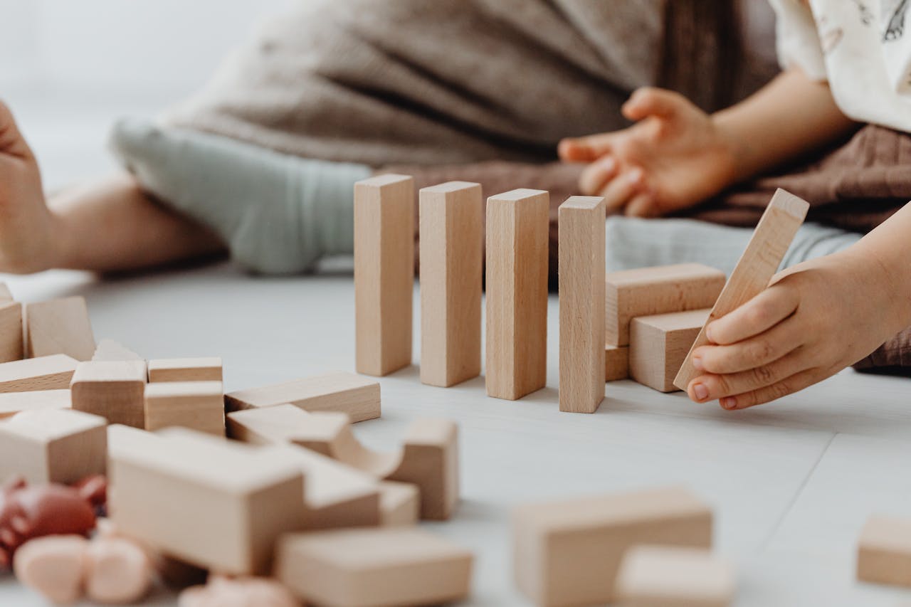Child practicing fine motor skills with wooden blocks during a pediatric occupational therapy session