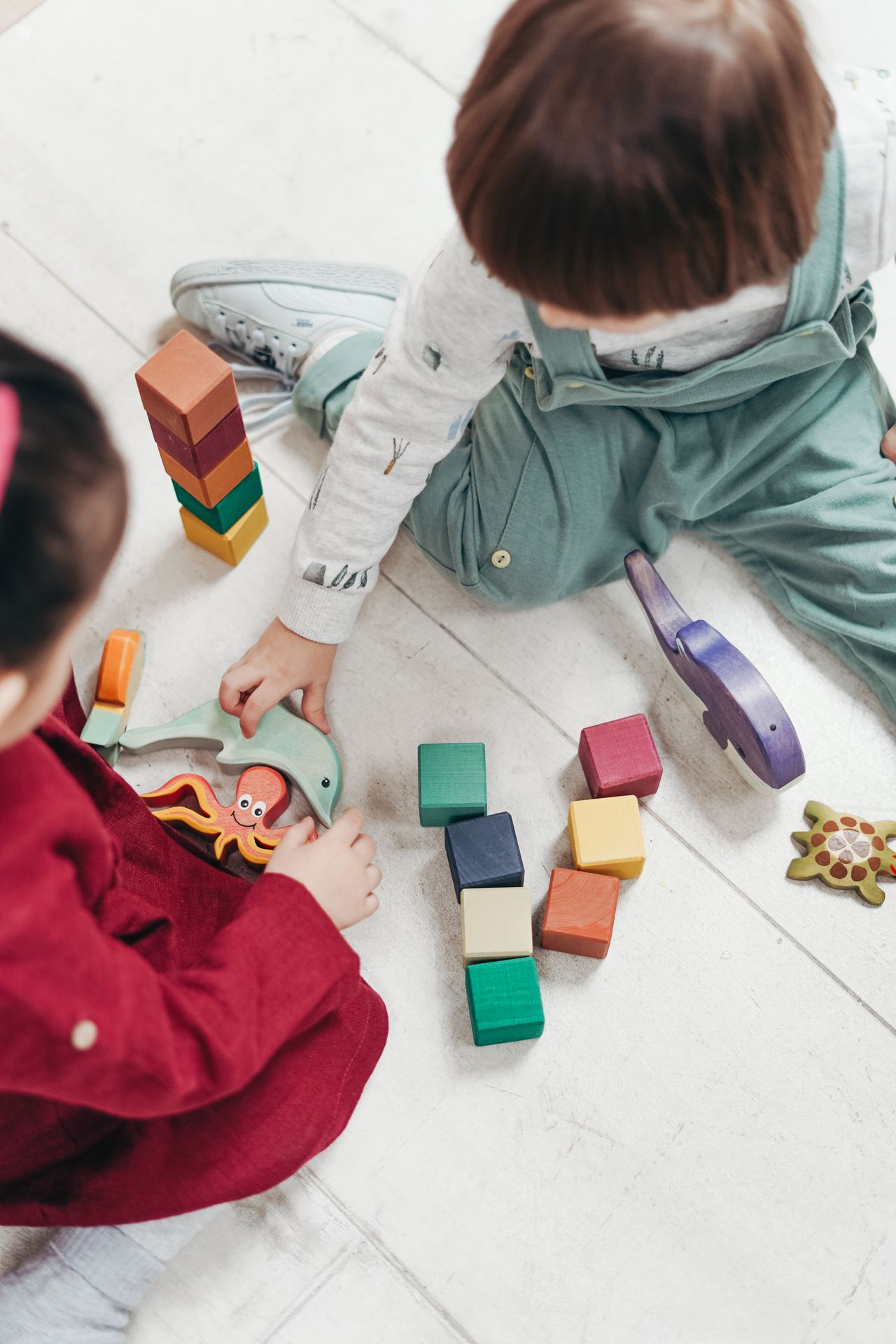 Two young children playing together with colorful blocks