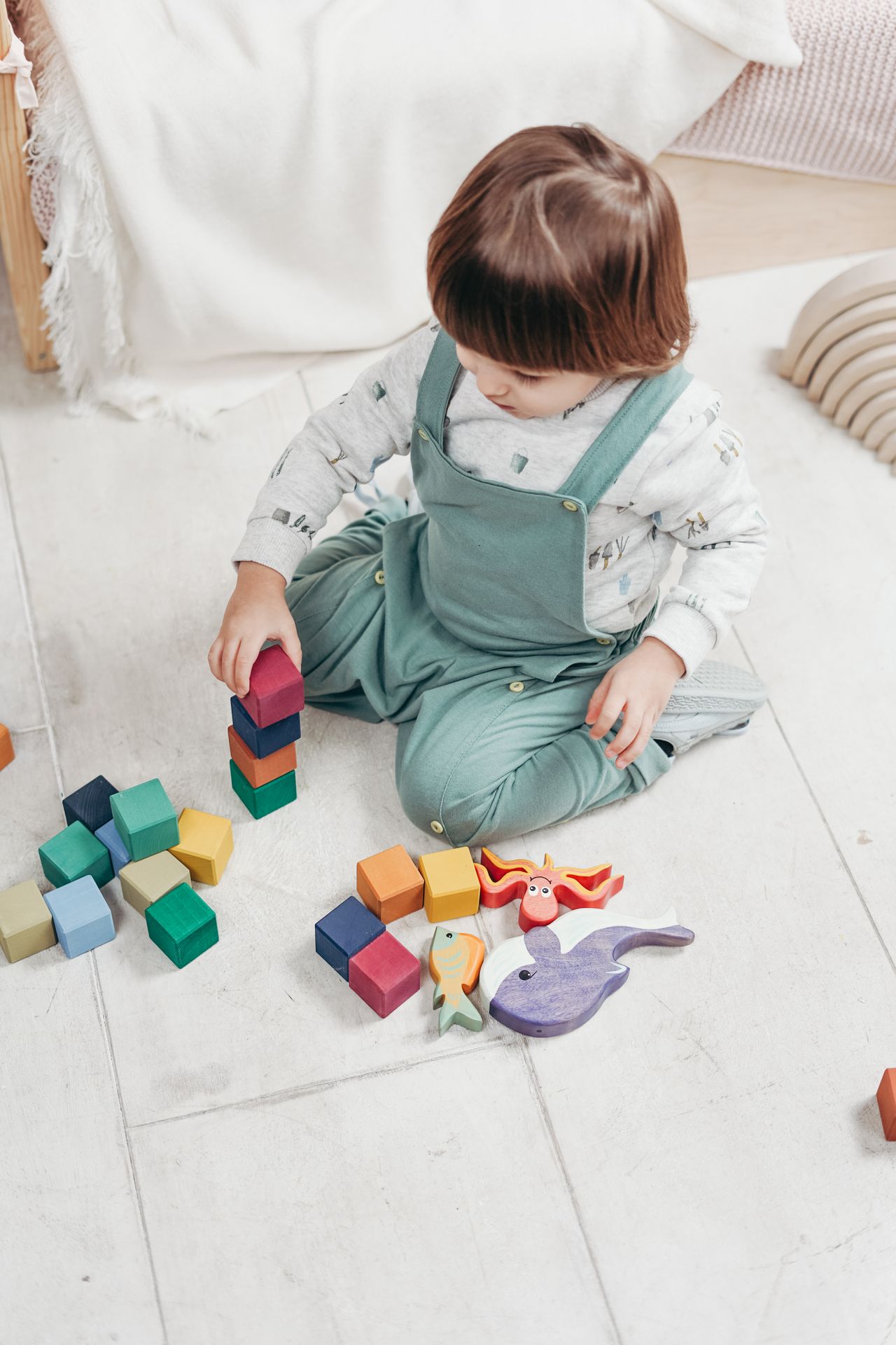A young child sitting on the floor engaged in play during a therapy session