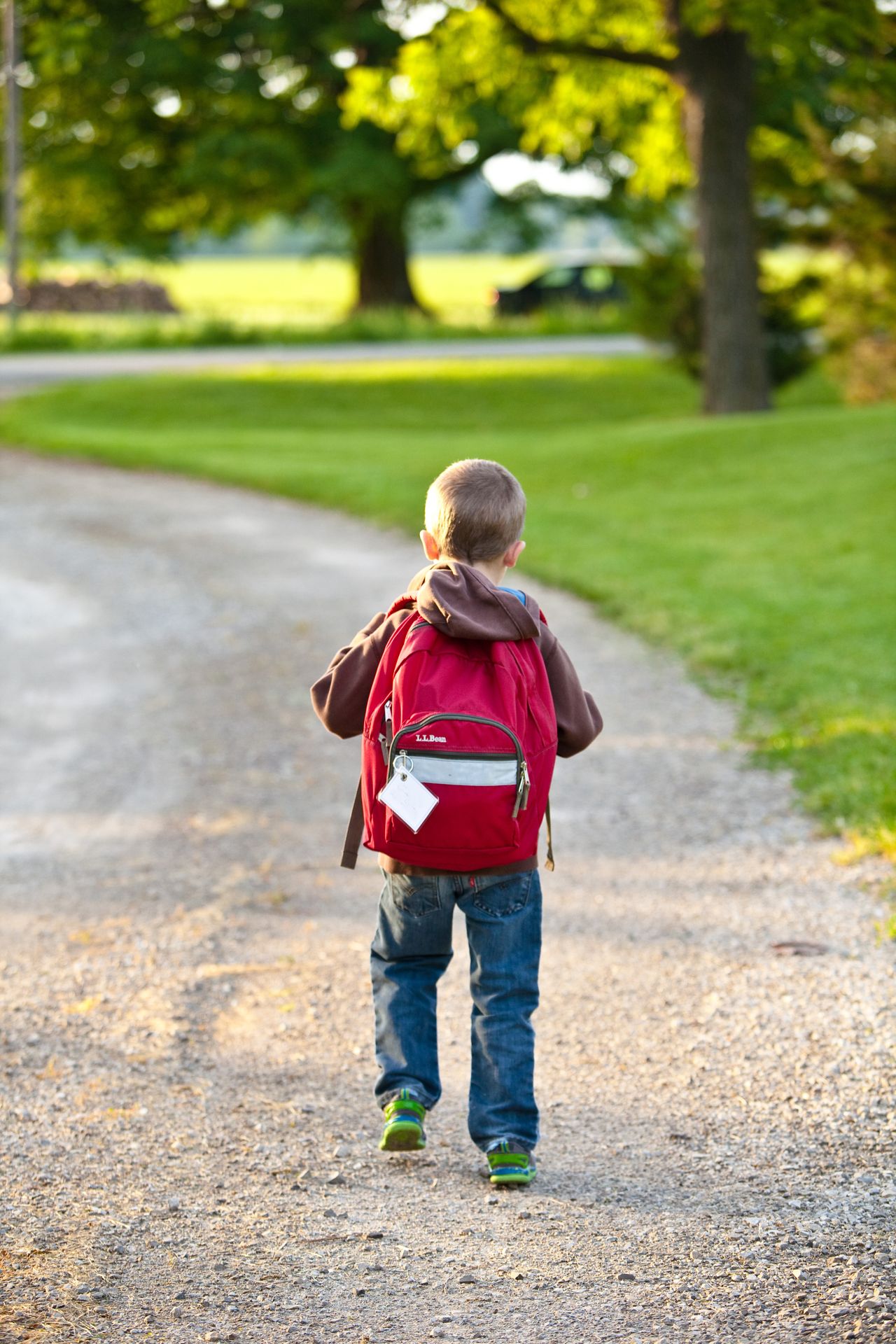 Young child putting on a backpack and practicing getting ready independently