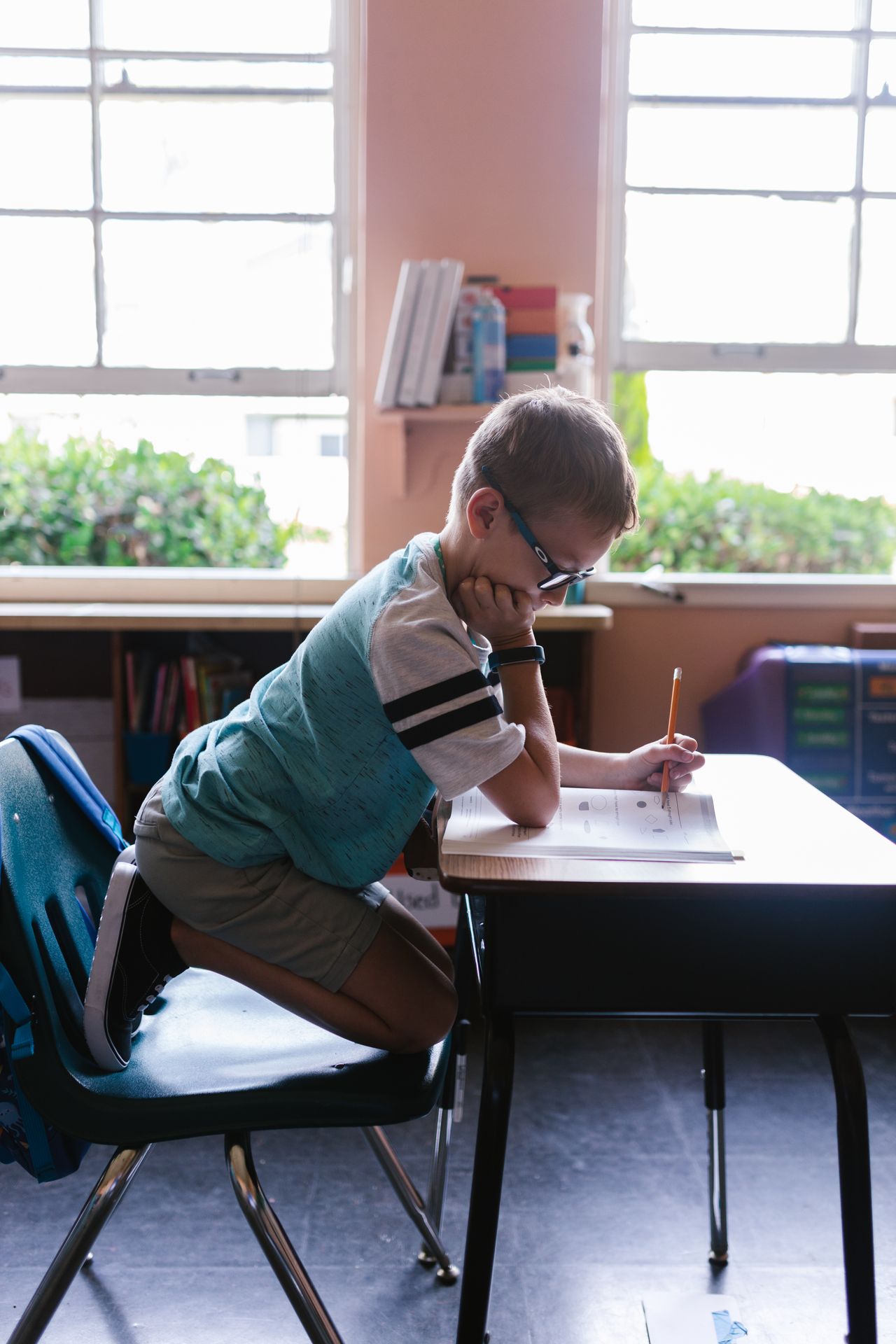 Young child working at a classroom desk during a school activity
