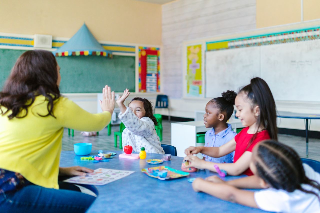 ABA Therapy Vero Beach - A teacher and a group of young children engaged in playful learning activities in a classroom